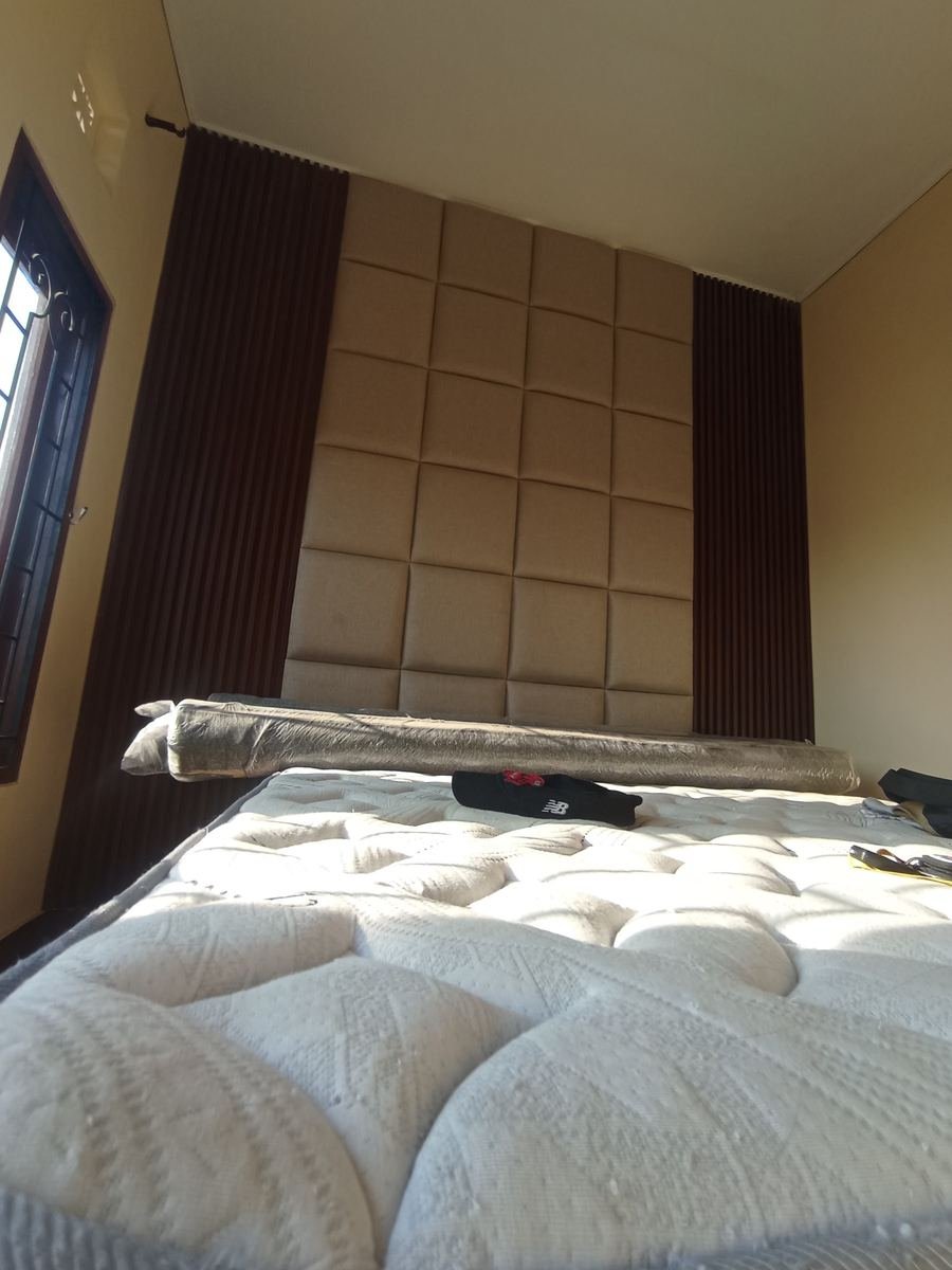 Floor-to-ceiling padded headboard in a villa bedroom